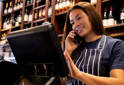 A bartender talking on the phone at a wine bar.