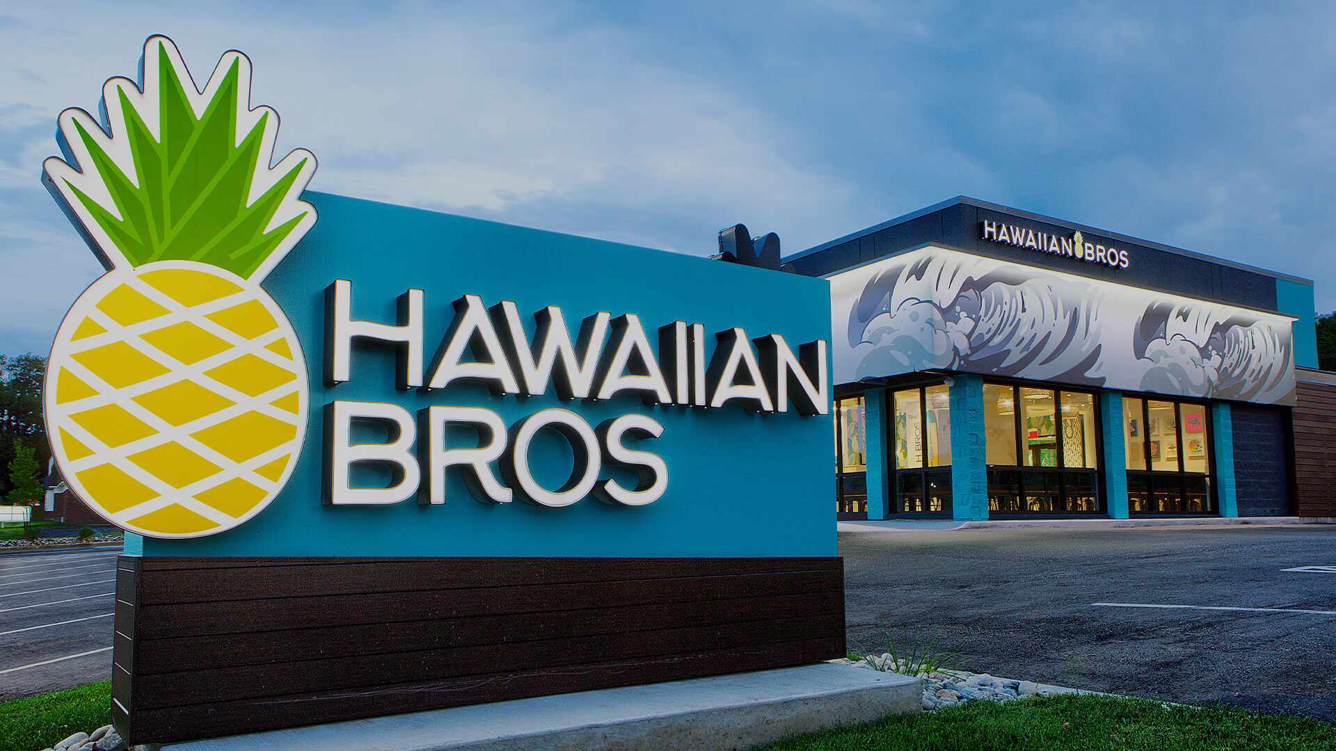 Hawaiian Bros restaurant exterior with a large pineapple logo sign in the foreground.