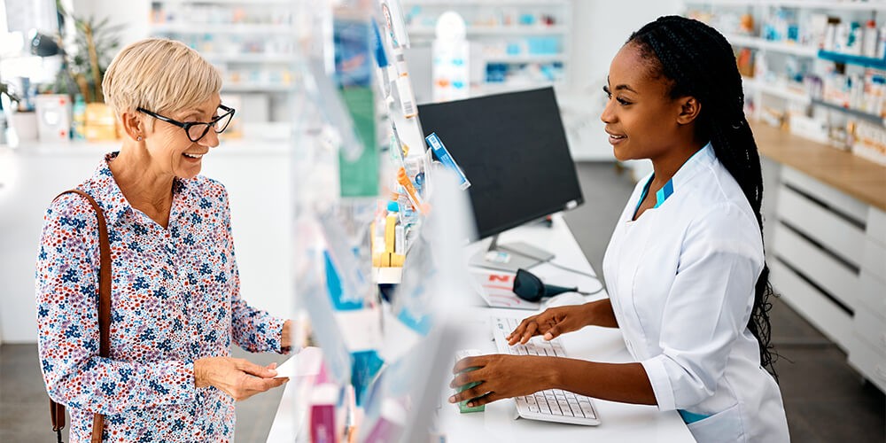 Two women in a pharmacy talking to each other.