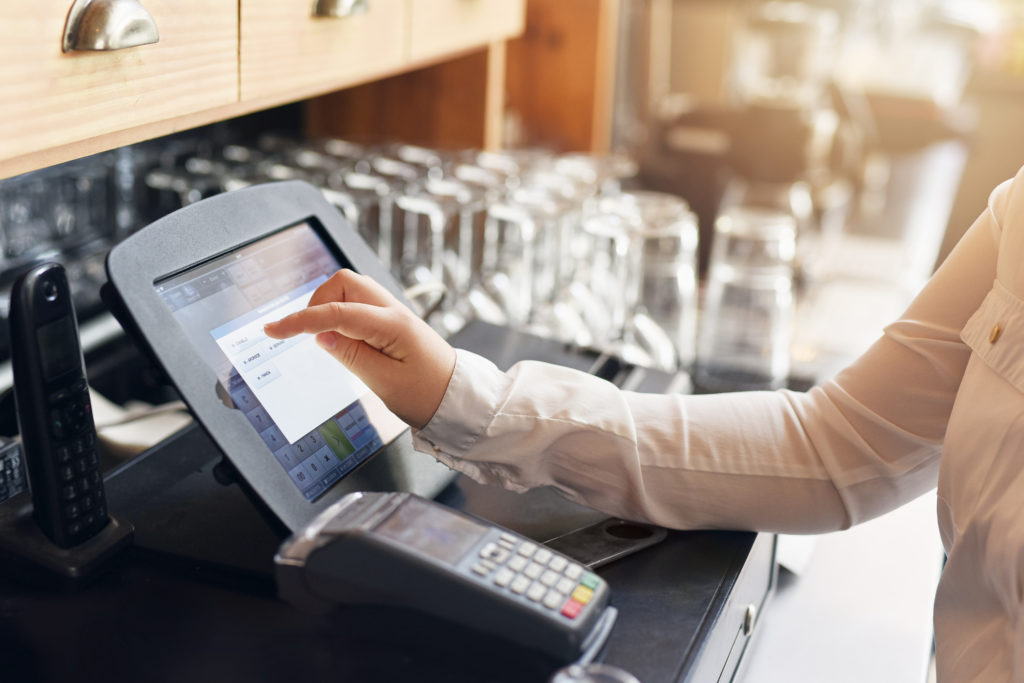 A woman is using a tablet at a bar.