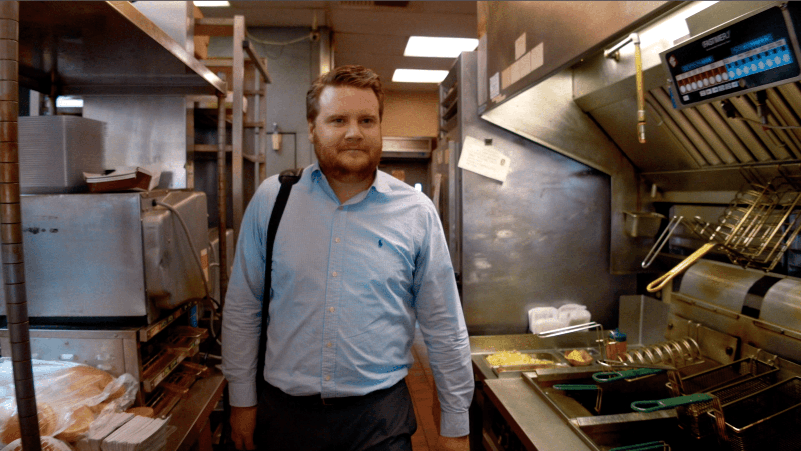 A man standing in a Jack in the Box restaurant kitchen.